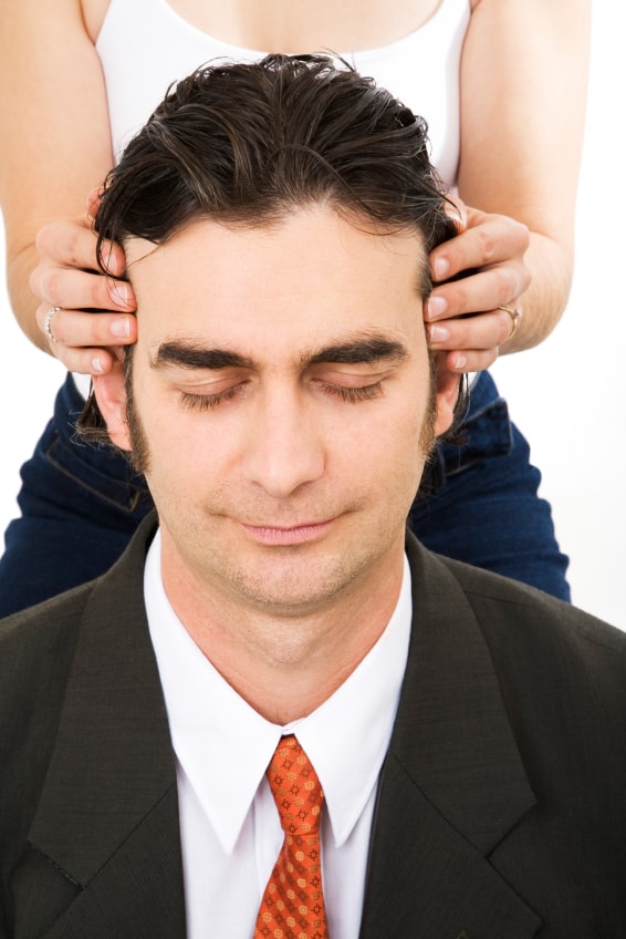 Lady giving businessman a head massage